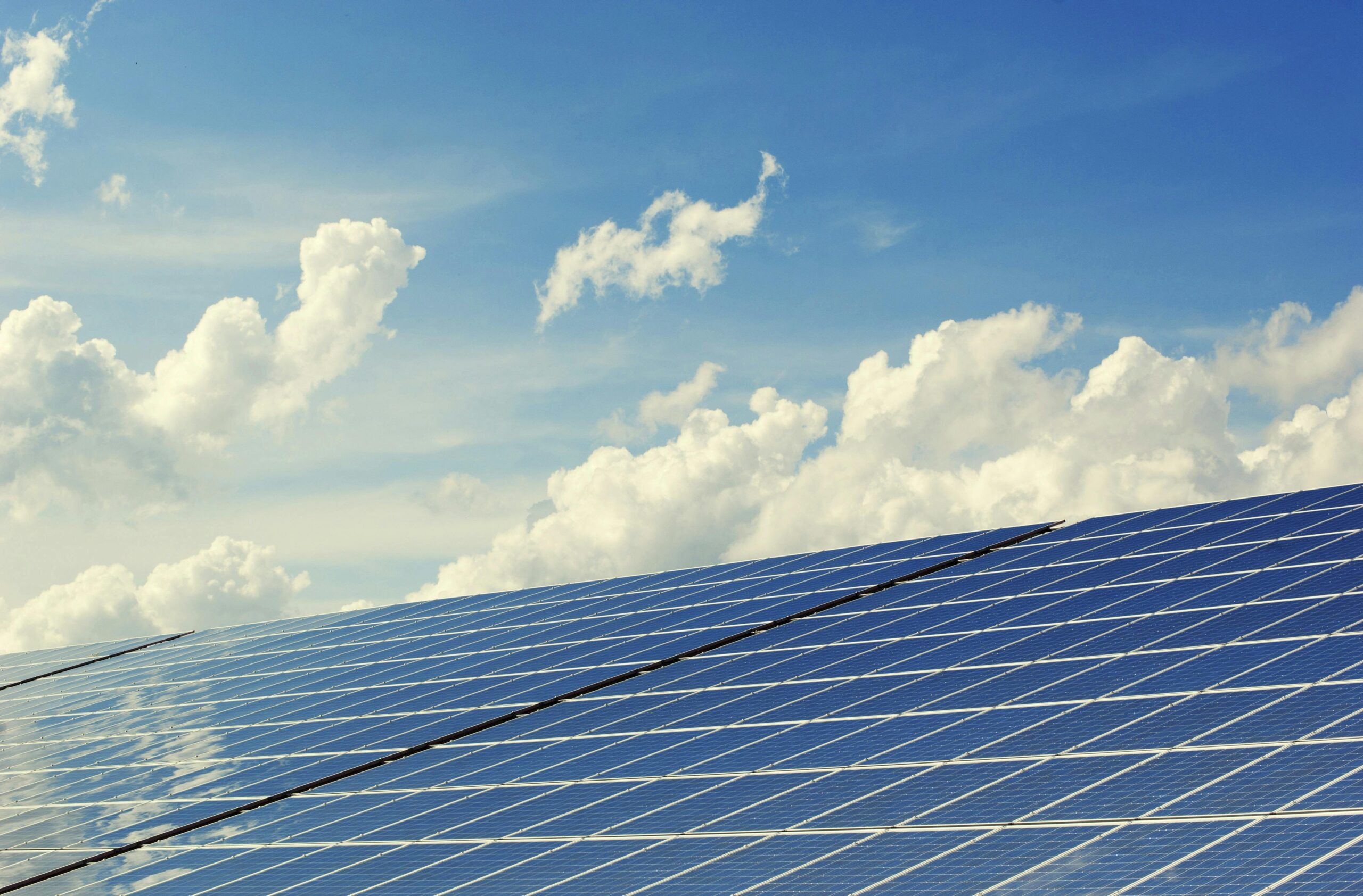 pexels-photo-356036-356036 | Maharishi vastu mimarisi Sleek modern solar panels under a vibrant blue sky with clouds, symbolizing clean energy.